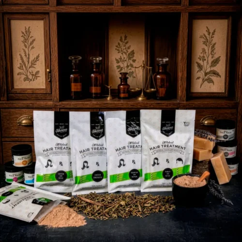 Henna hair treatment suite laid out on apothecary table with loose herbs.